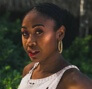 A profile image of a woman wearing a white tank top