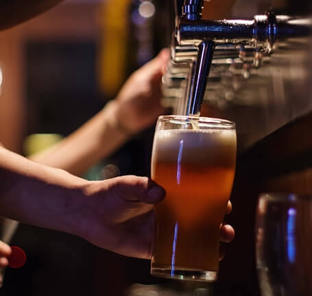 A beer being poured from a row of taps